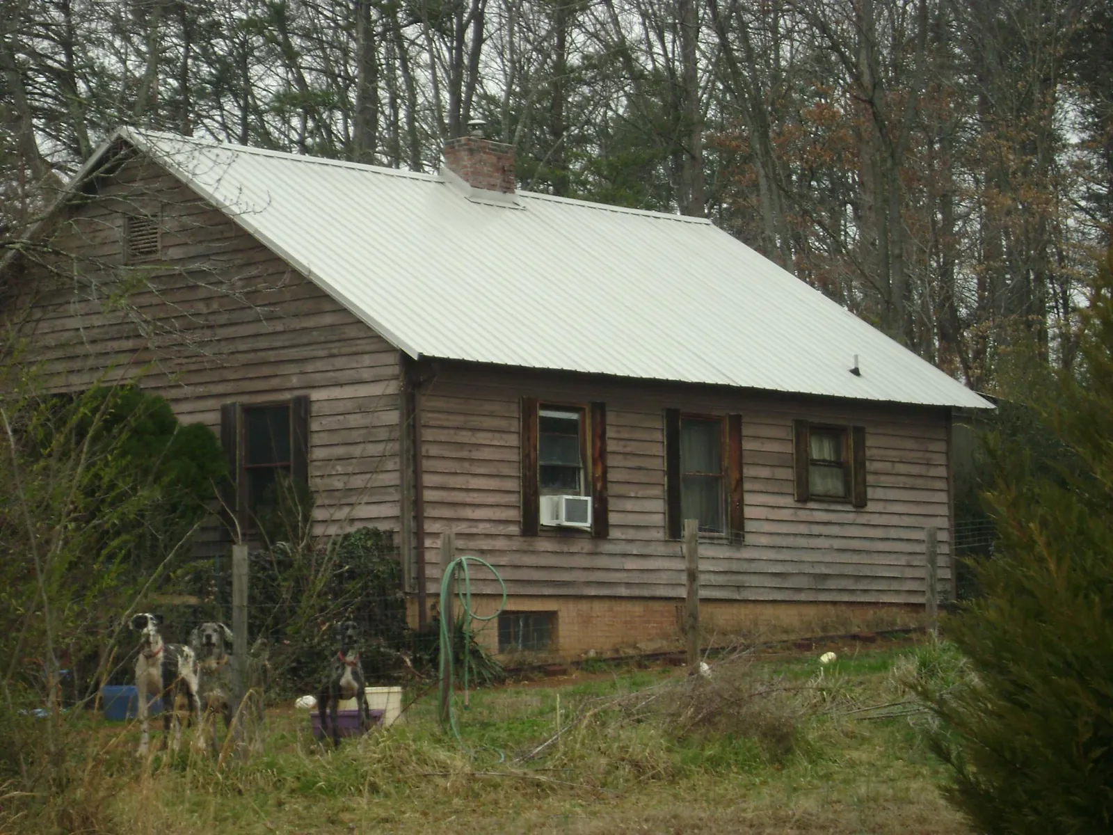 White metal roof on an old wood sided farmhouse, from a Metal Roof Installation job in Paris